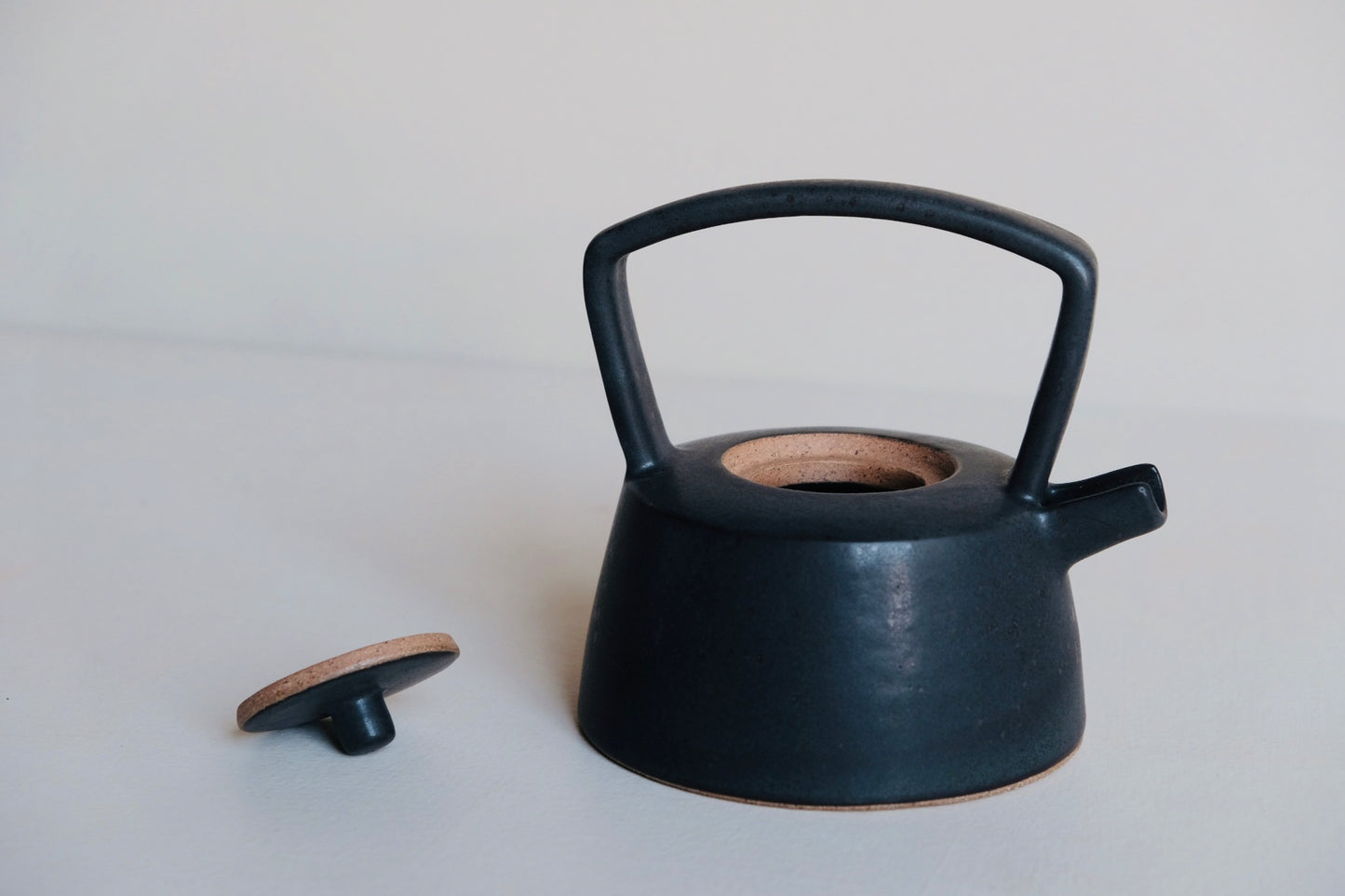 black teapot with the lid off