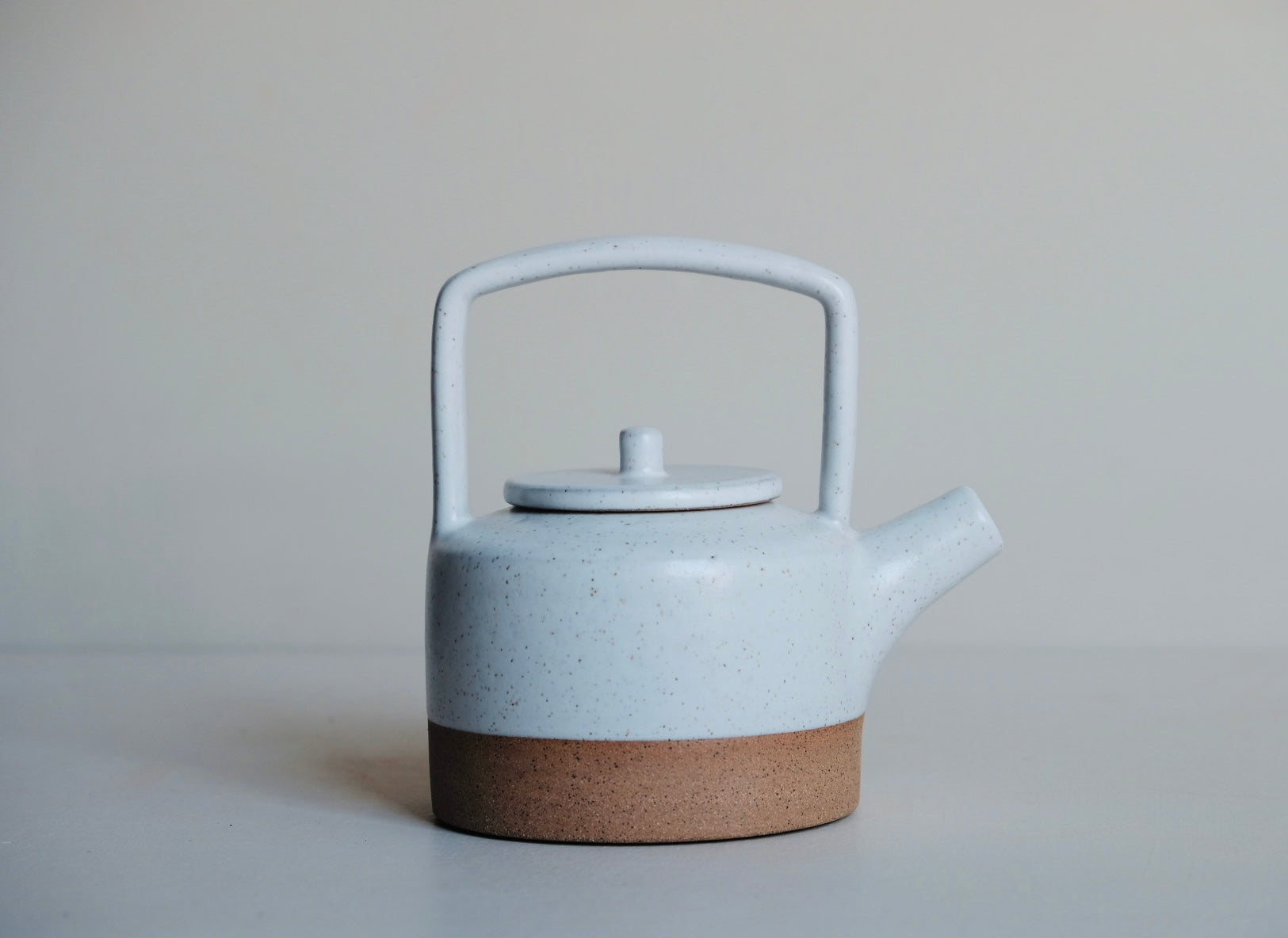 White teapot with raw clay base