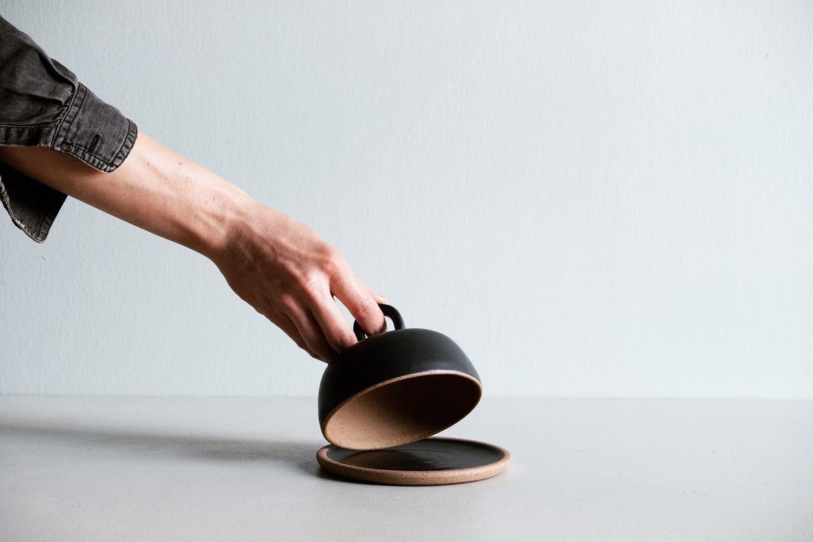 A round butter dish dipped in black satin glaze.